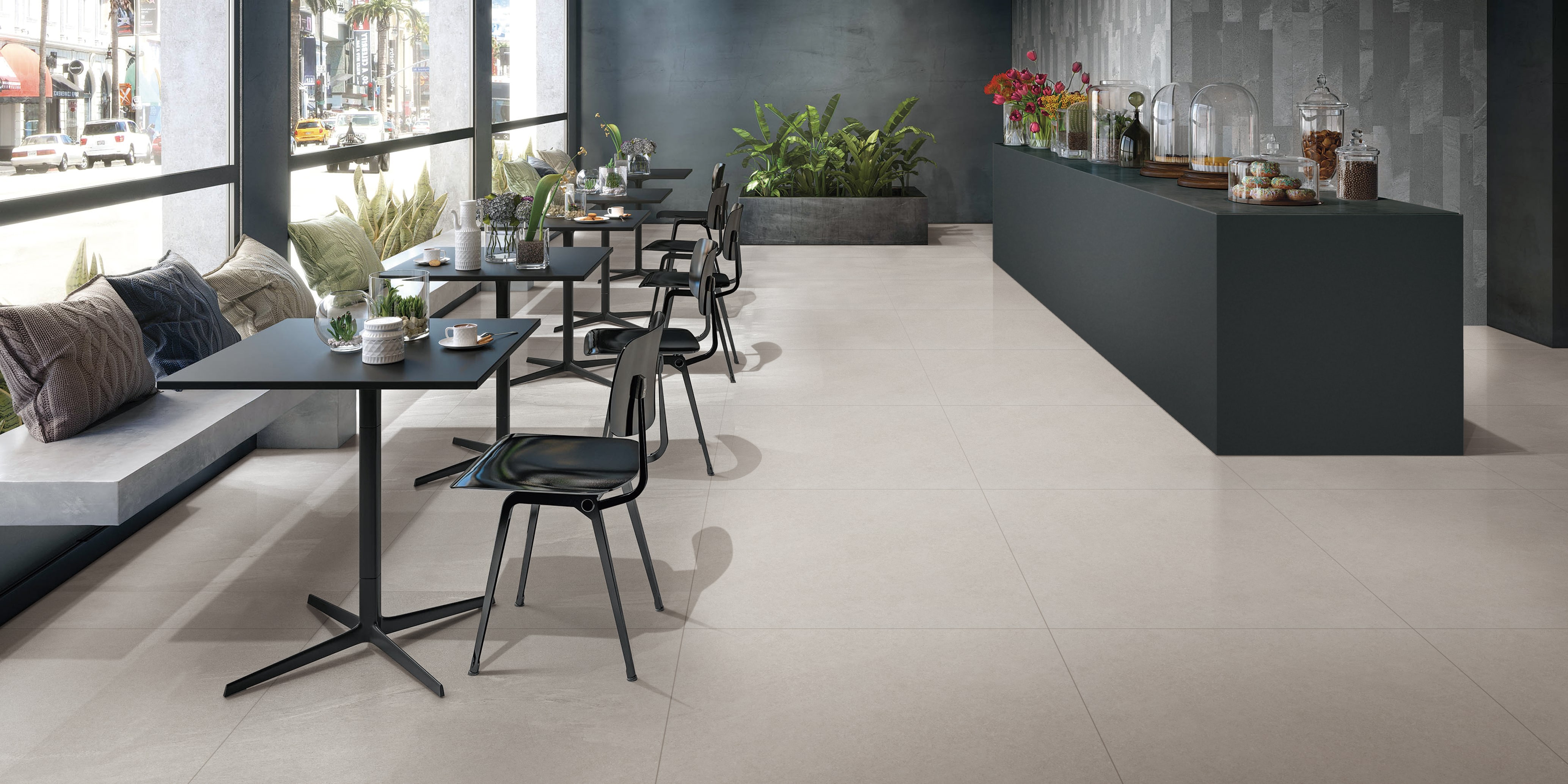 Spacious cafe interior featuring large format neutral floor tiles